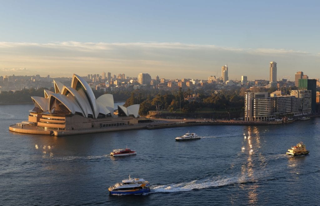 A view of the Sydney Opera House from above with boats on the river