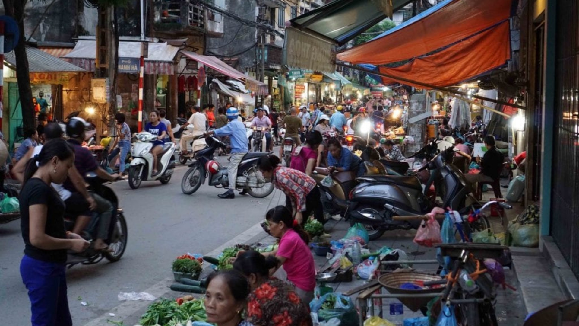 The streets markets in Hanoi full of people and motorbikes