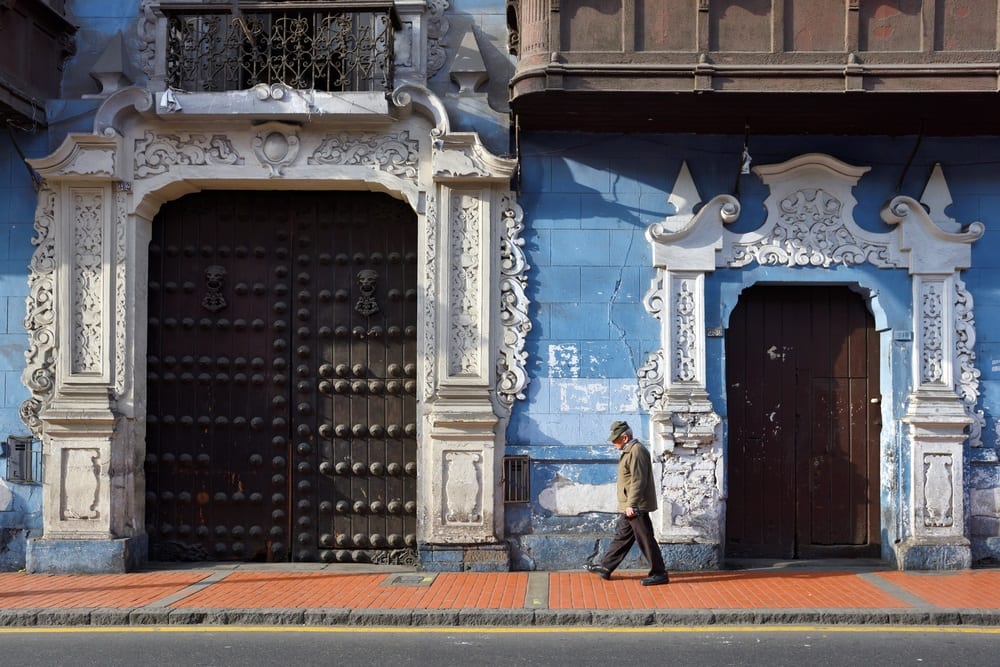 A man walking in front of the Casa de Osambela in Peru