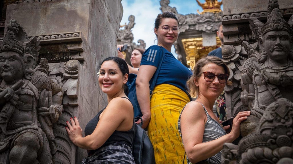 Flashpackers turn to smile whilst climbing temple steps in Bali