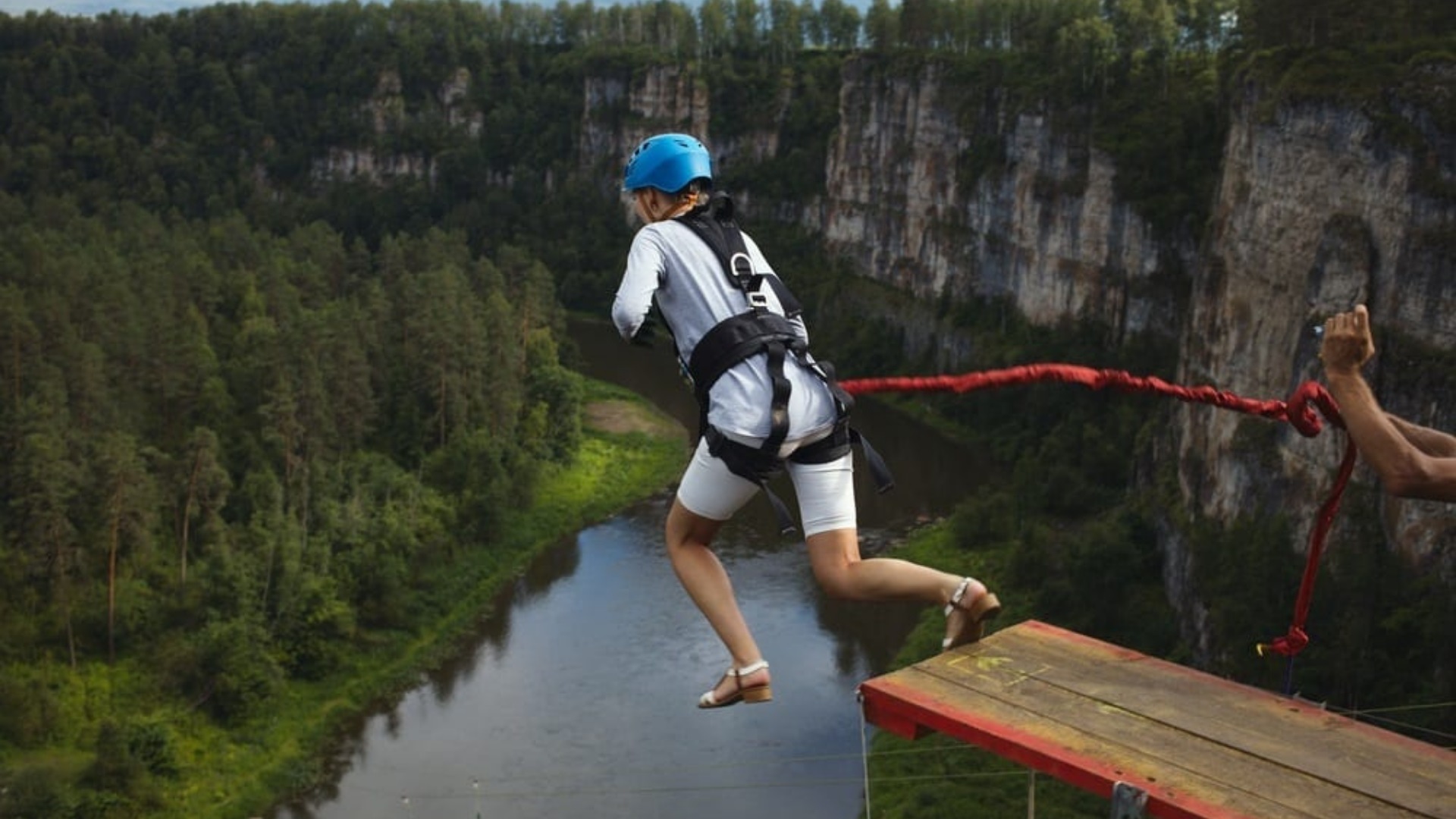 A woman bungee-jumping into a canyon