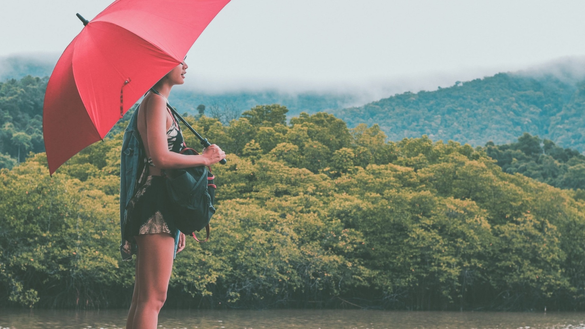 A woman holding an umbrella in the jungle