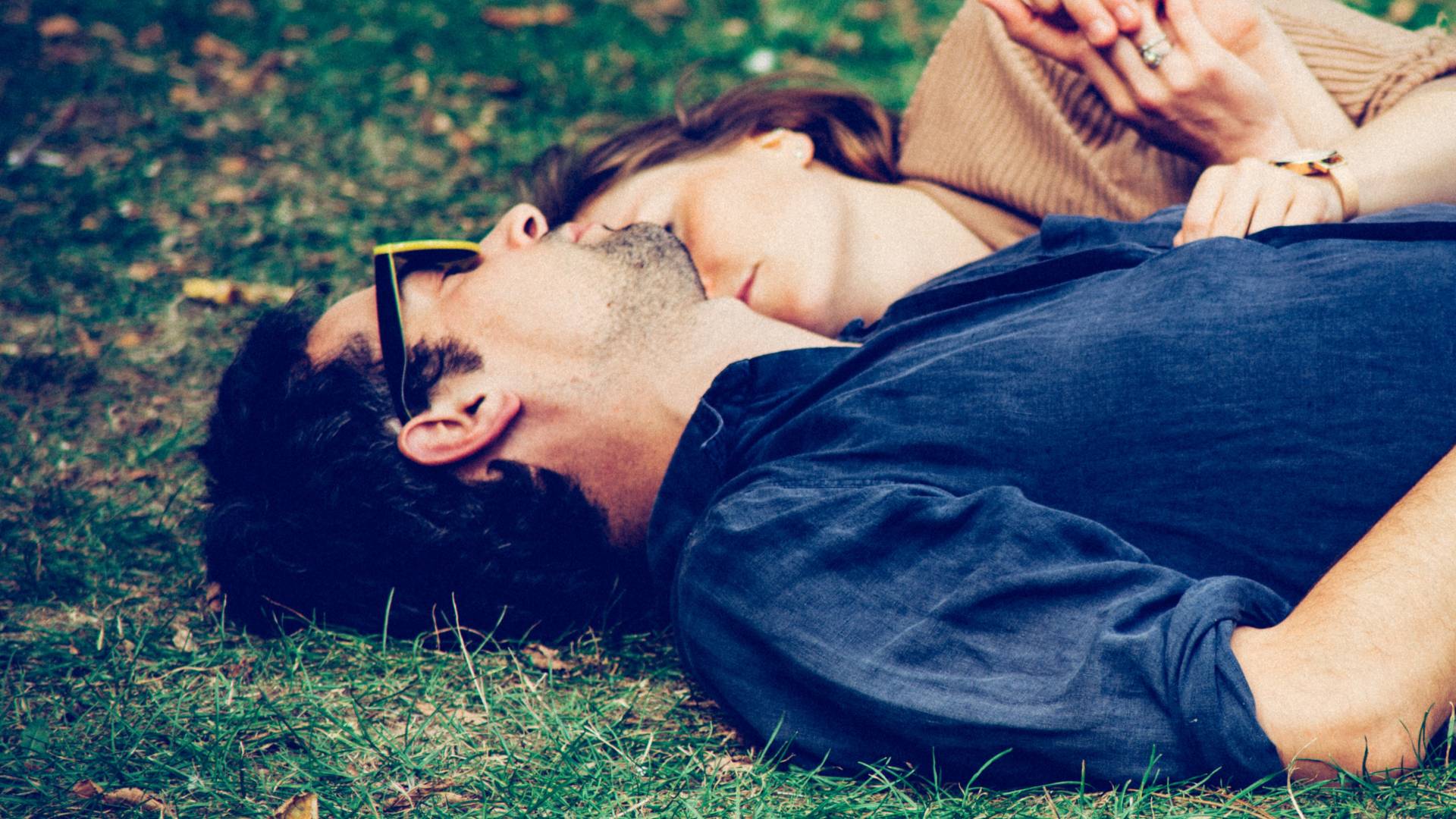 man and woman embracing on grass