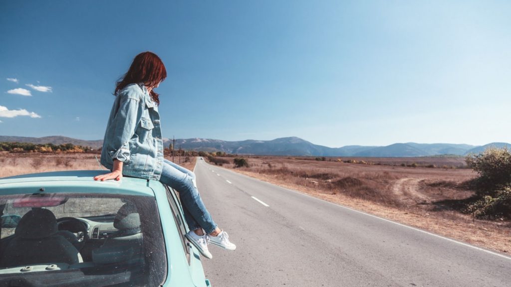 A woman sitting on a car