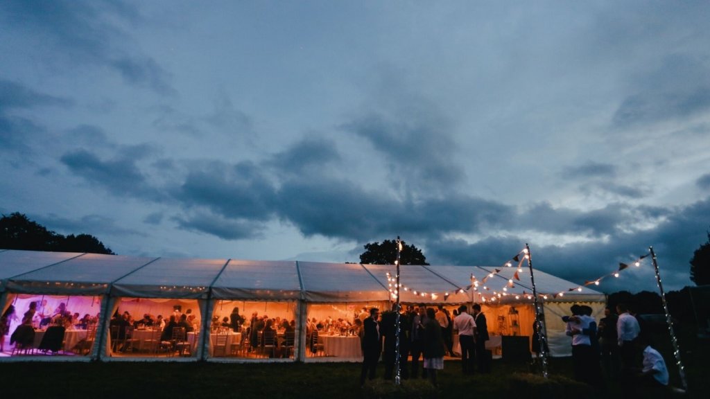 A long tent of people celebrating at night