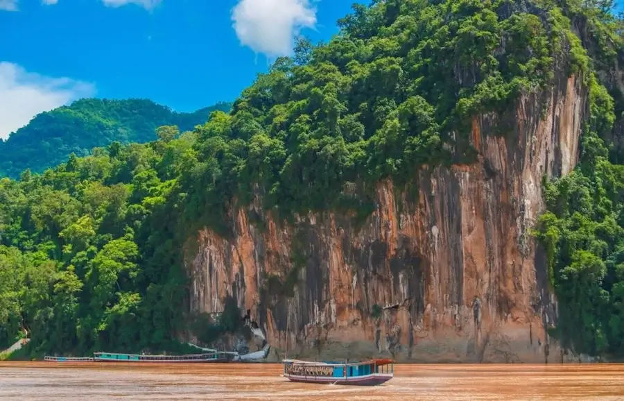 A river cruise in front of the Pak Ou Caves on the Mekong River 